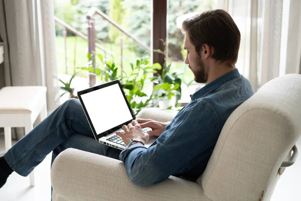 Giovane uomo che lavora sul suo computer portatile con schermo spazio vuoto copia per il tuo messaggio di testo pubblicitario in home office — Foto Stock