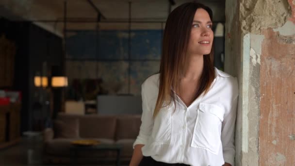 Mujer europea adulta joven y sonriente confiada mirando la cámara de pie en la oficina, posando para un retrato de cerca en interiores — Vídeos de Stock