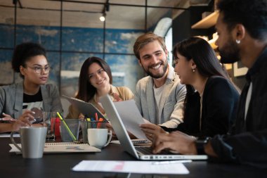 Modern ofiste çalışan bir grup çok ırklı genç insan. İş adamları toplantı sırasında iş başında.
