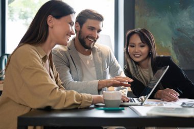 Modern ofiste çalışan bir grup çok ırklı genç insan. İş adamları toplantı sırasında iş başında.