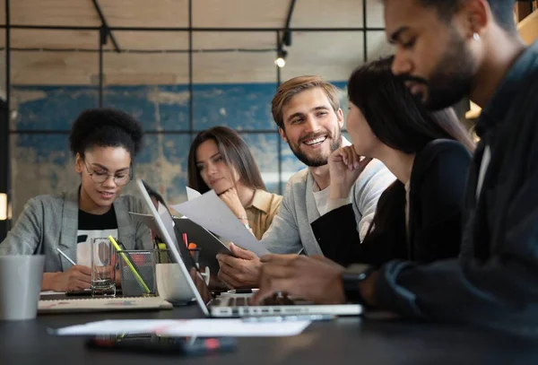 Group of young multiracial people working in modern office. Businessmen at work during meeting.