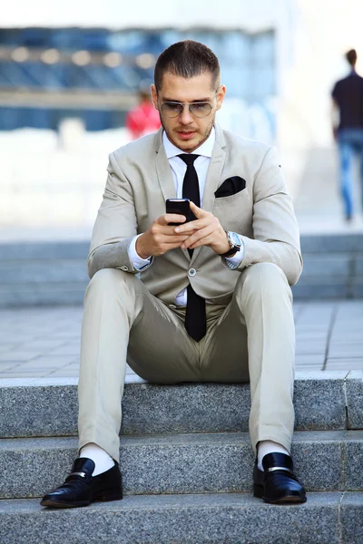 Homem de negócios bonito com telefone móvel — Fotografia de Stock