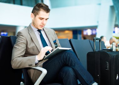 Havaalanında tablet bilgisayar kullanarak iş adamı
