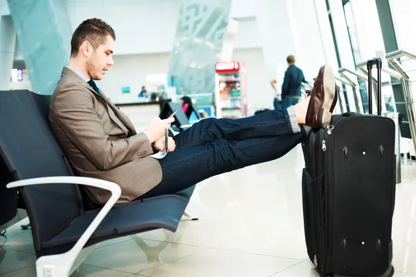 Бізнесмен в аеропорту зі смартфоном — стокове фото