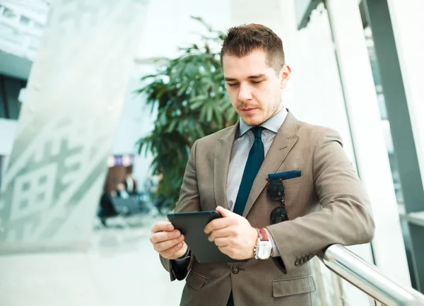 Geschäftsmann nutzt Tablet-Computer am Flughafen — Stockfoto