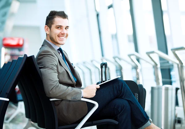 Biznesmen przy użyciu komputera typu tablet na lotnisku — Zdjęcie stockowe