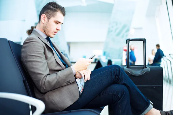 Uomo d'affari in aeroporto con smartphone — Foto Stock