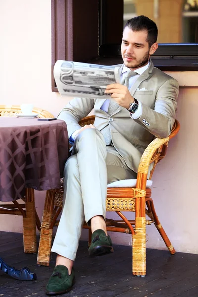 Empresário lendo jornal no café — Fotografia de Stock