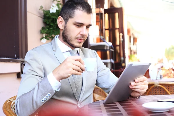 Empresário usando tablet digital no café — Fotografia de Stock