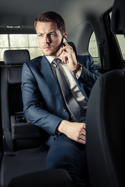 Businessman in the car with mobile phone