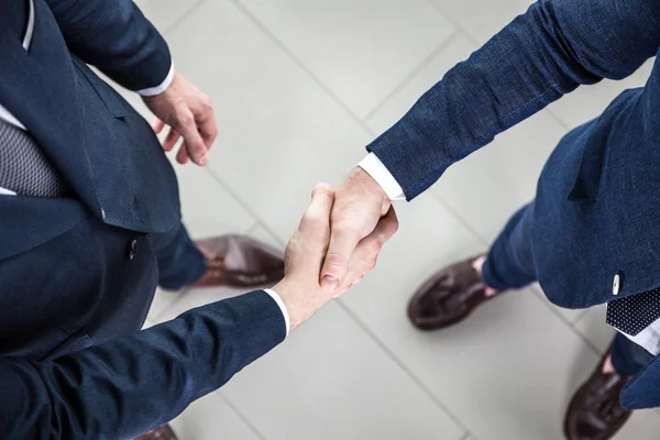 Empresários apertando as mãos, terminando uma reunião — Fotografia de Stock