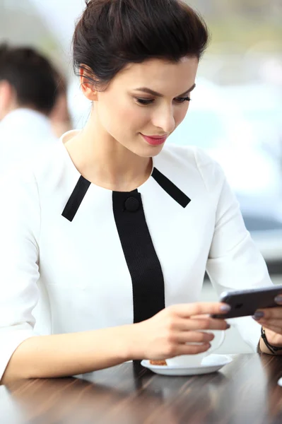 Pensive businesswoman reading an article on tablet computer in a — Stock Photo, Image