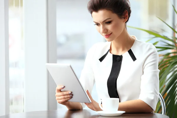 Pensive businesswoman читає статтю на планшетному комп'ютері в — стокове фото
