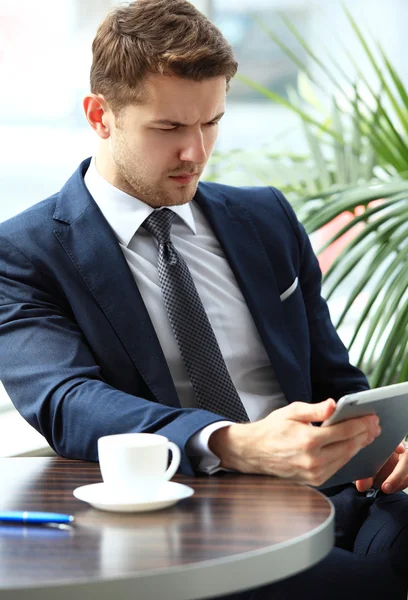 Imagen del joven feliz usando tableta digital en la cafetería — Foto de Stock