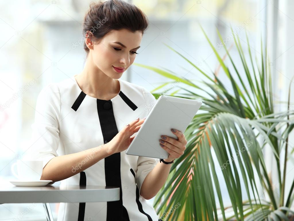 Pensive businesswoman reading an article on tablet computer