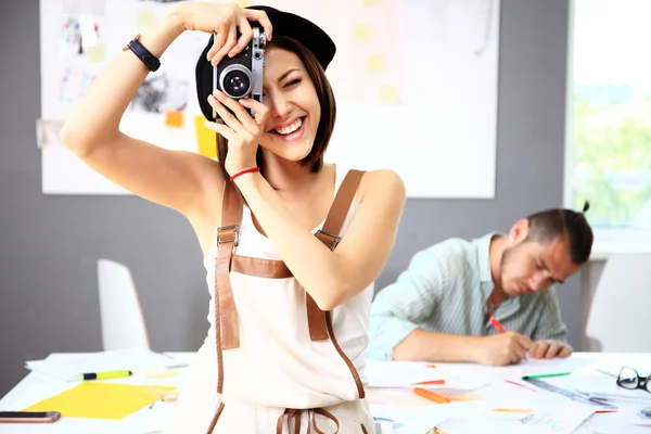 Woman with camera in office — Stockfoto