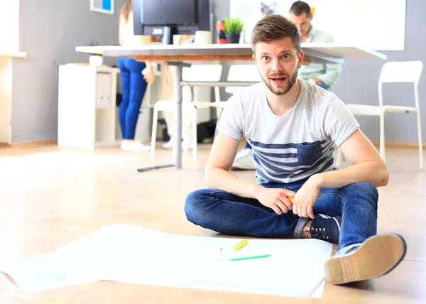 Designerin sitzt im Büro am Boden — Stockfoto