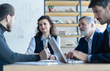 Kurumsal ofiste birlikte çalışan başarılı iş adamları, analitik rapor sunar
