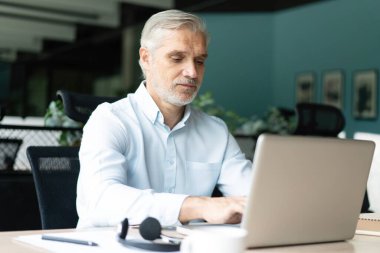 Olgun 40 'lar odaklı iş adamı, dizüstü bilgisayarla çalışan yönetici ofiste veri tabanında araştırma yapan. Başarılı iş adamı, lider, CEO müdürü, borsa şifreli para ticareti.