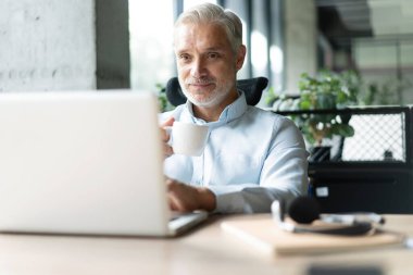 Olgun 40 'lar odaklı iş adamı, dizüstü bilgisayarla çalışan yönetici ofiste veri tabanında araştırma yapan. Başarılı iş adamı, lider, CEO müdürü, borsa şifreli para ticareti.