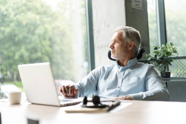 Mutlu Avrupalı iş adamı CEO 'su bilgisayar kullanıyor, daktilo kullanıyor, modern ofiste çalışıyor, çevrimiçi veri pazarı analizi yapıyor, bilgisayar kopyalama alanı olan dizüstü bilgisayara bakarak teknoloji stratejisi planlıyor.