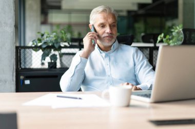 Ofisteki iş adamı. İş yerinde konuşan olgun, yakışıklı bir adam..