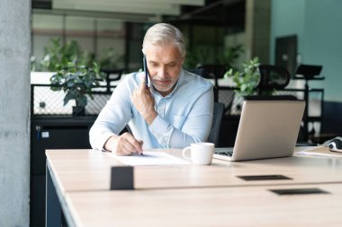 Ofisteki iş adamı. İş yerinde konuşan olgun, yakışıklı bir adam..