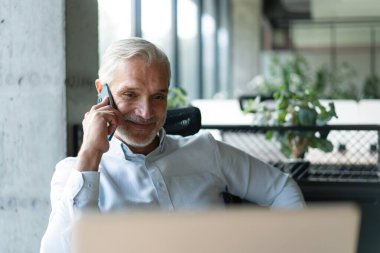 Ofisteki iş adamı. İş yerinde konuşan olgun, yakışıklı bir adam..