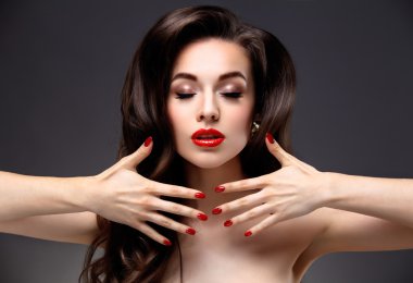 Uzun kahverengi dalgalı saçlı güzellik modeli kadın. Sağlıklı saç ve güzel profesyonel makyaj. Kırmızı dudaklar ve dumanlı gözler makyaj. Muhteşem seksi kadın portre. Saç bakım, cilt bakım kavramı