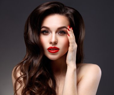 Uzun kahverengi dalgalı saçlı güzellik modeli kadın. Sağlıklı saç ve güzel profesyonel makyaj. Kırmızı dudaklar ve dumanlı gözler makyaj. Muhteşem seksi kadın portre. Saç bakım, cilt bakım kavramı