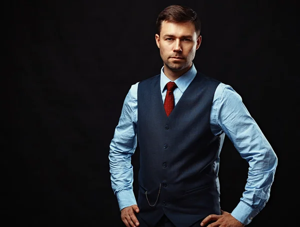 Handsome young business man standing on black background — Stock Photo, Image