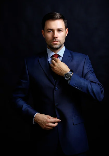 Handsome young business man standing on black background — Stock Photo, Image