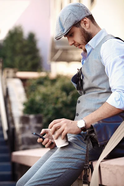 Young urban businessman professional on smartphone walking in street using app texting sms message on smartphone