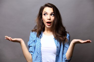 Gri arka plan üzerinde şaşırtıcı genç kadın