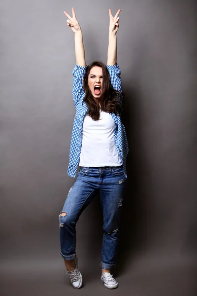 Winnaar vrouw vieren van succes geïsoleerd op grijze achtergrond. — Stockfoto