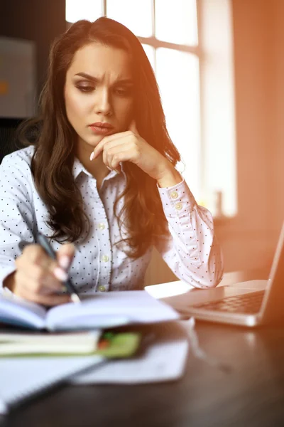 Financial manager taking notes when working on report — Stock Photo, Image