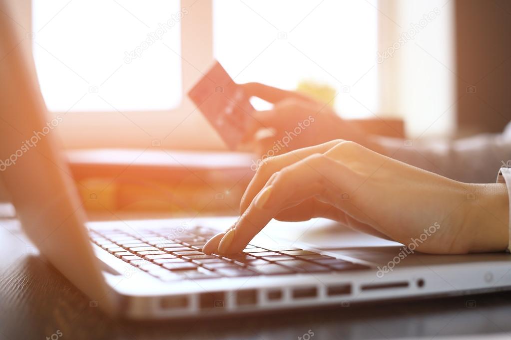 Close Up Of A woman Shopping Online Using Laptop With Credit Card