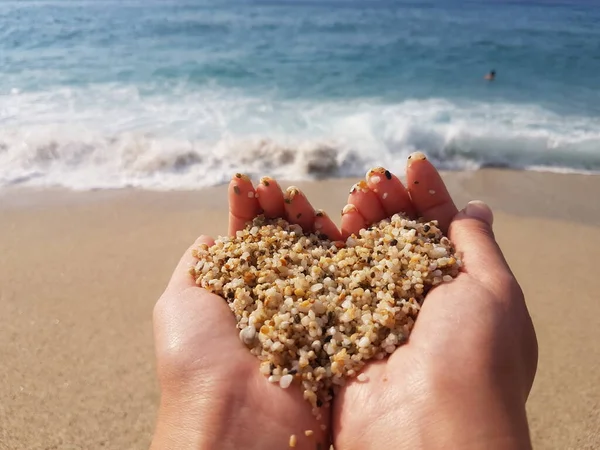 Corazón suave que forma las manos femeninas sobre el mar y la playa — Foto de Stock