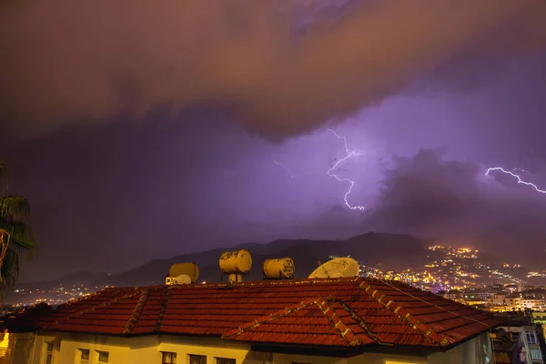 Starkes Gewitter über nächtlichen Bergen und Städten. Große helle Blitze aus nächster Nähe. Mittelmeerwinternachtgewitter. Alanya, Türkei — Stockfoto