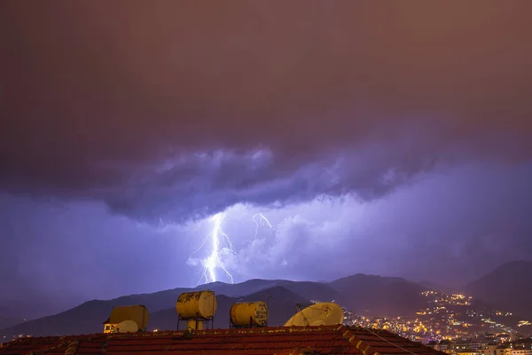 Starkes Gewitter über nächtlichen Bergen und Städten. Große helle Blitze aus nächster Nähe. Mittelmeerwinternachtgewitter. Alanya, Türkei — Stockfoto