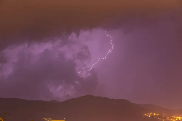 Forte temporale sulle montagne notturne e sulla città. Grande fulmine luminoso da vicino. Tempesta notturna invernale mediterranea. Alanya, Turchia — Foto Stock