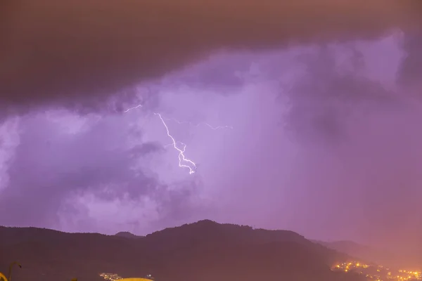 Forte tempête au-dessus des montagnes nocturnes et de la ville. Gros plan éclair lumineux. Orage nocturne méditerranéen d'hiver. Alanya, Turquie — Photo