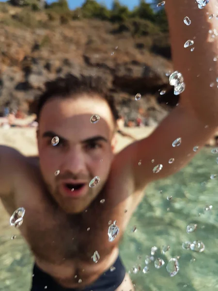 Happy adult man having fun sea at sunny light day. Smiling men in water splashing, summer vacations — Stockfoto