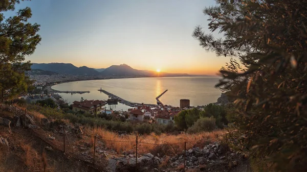 Beautiful sunrise panorama filled with the golden light of the dawn sun against the backdrop of the sea and mountains. Alanya, Turkey — Stok fotoğraf