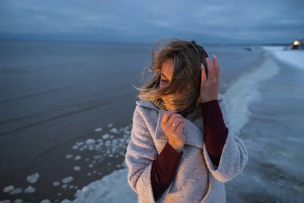Krásná žena na zimním moři pobřeží večer čas teplé světlo — Stock fotografie
