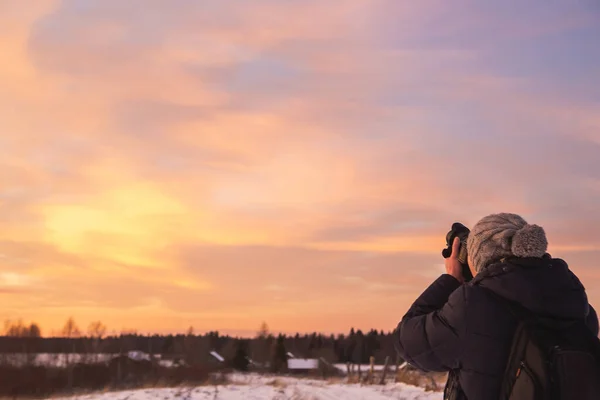 Mannelijke amateur fotograaf maakt foto 's van kleurrijke winterzonsondergang. Winterwonderland met paarse kleuren — Stockfoto