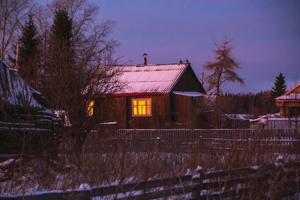 Velhas casas de aldeia russas no frio amargo. Inverno crepúsculo paisagem. — Fotografia de Stock