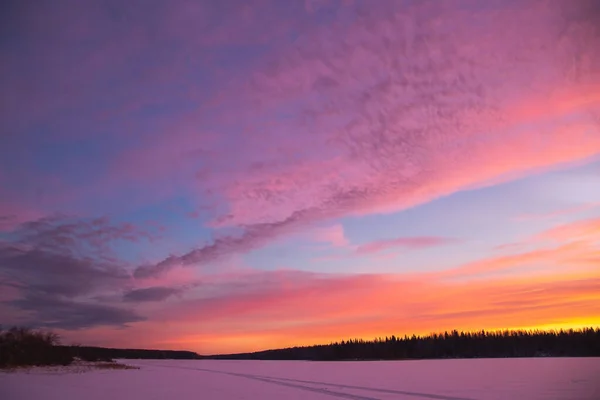 Pôr do sol paisagem de inverno com estrada coberta de neve em cores violeta e rosa — Fotografia de Stock