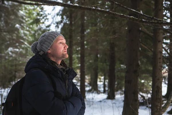 Junger Mann Backpacker im Winter verschneiten Wald. Aktives Hobby. Wandern im verschneiten Kiefernwald. Kopierraum — Stockfoto