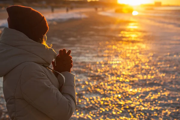 Junge Frau im Winter genießt Wintersonne. Rotes Sonnenuntergangslicht — Stockfoto